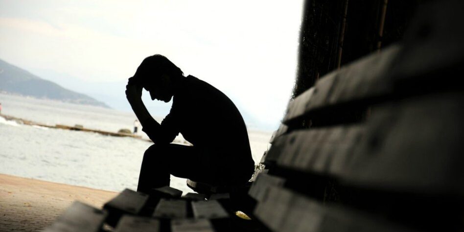 Young man sitting looking upset